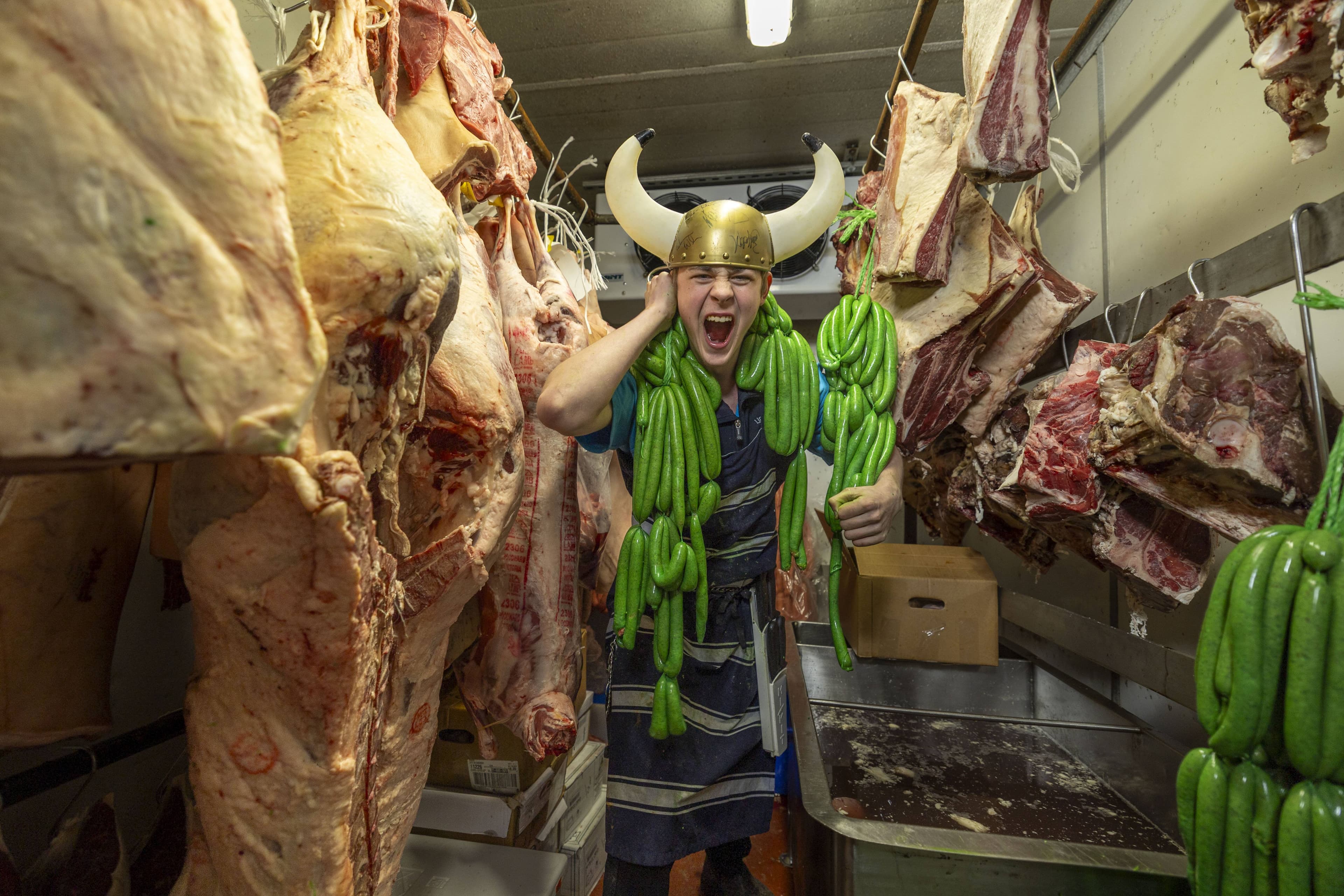 1st year apprentice butcher Kane Stephens, 16 years old, with racks of Lindbeck butcher’s. Raiders lime green sausages. Picture by Gary Ramage