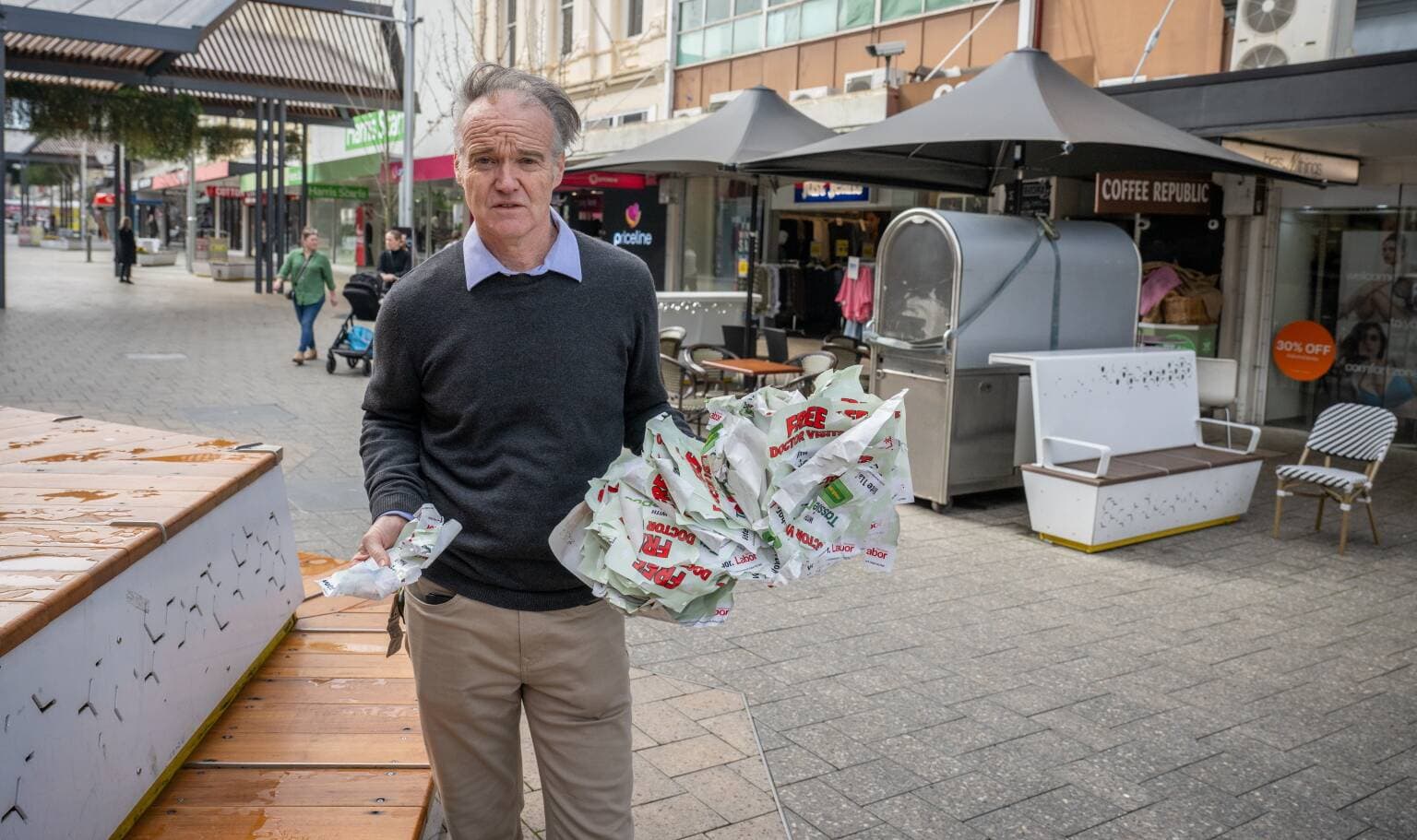 Robin Smith of Coffee Republic with handfulls of the election stickers in the Brisbane street mall on August 14.