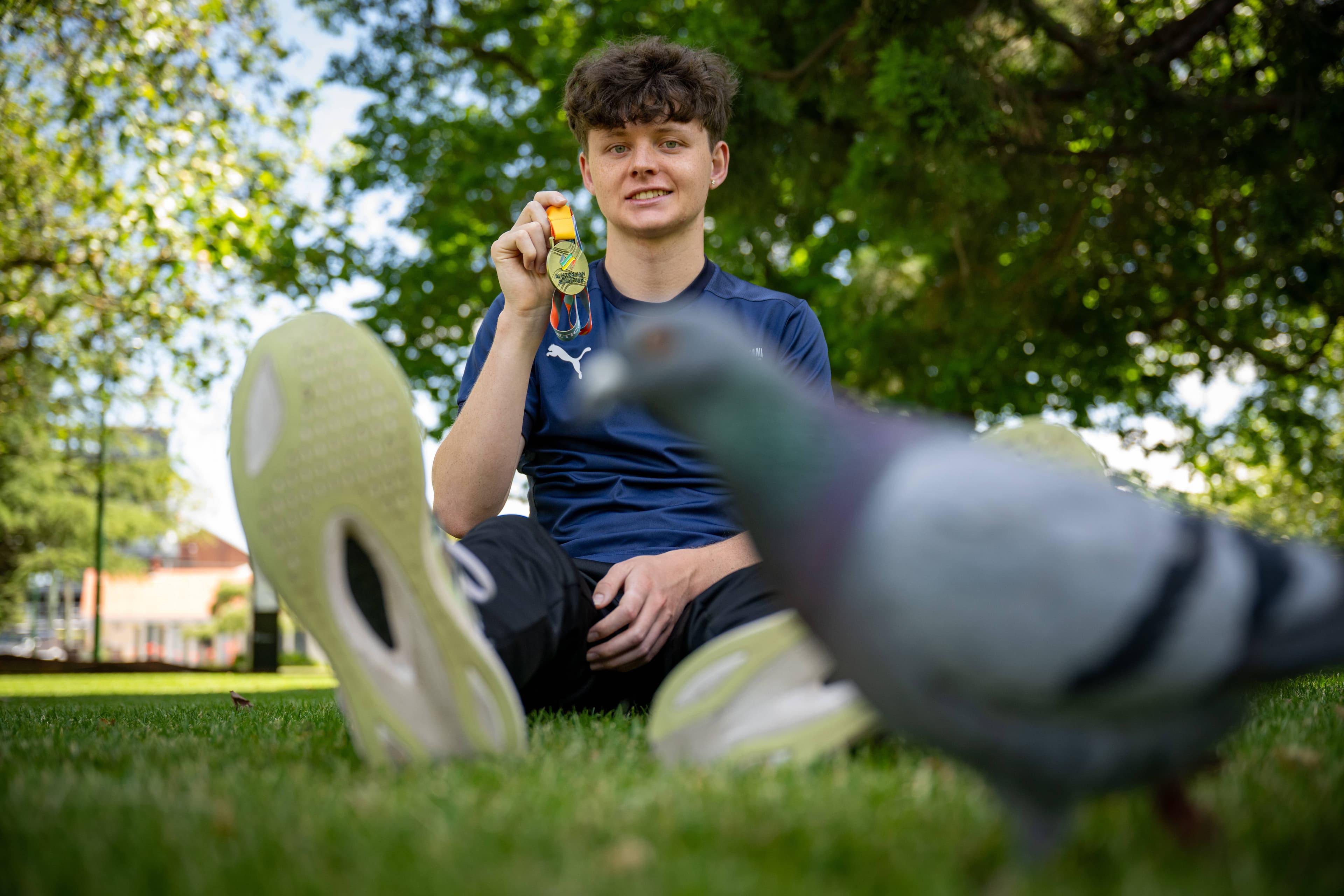 Photo-bomber pidgeon with Sam Lindsay of Launceston and his gold medal for race walking.