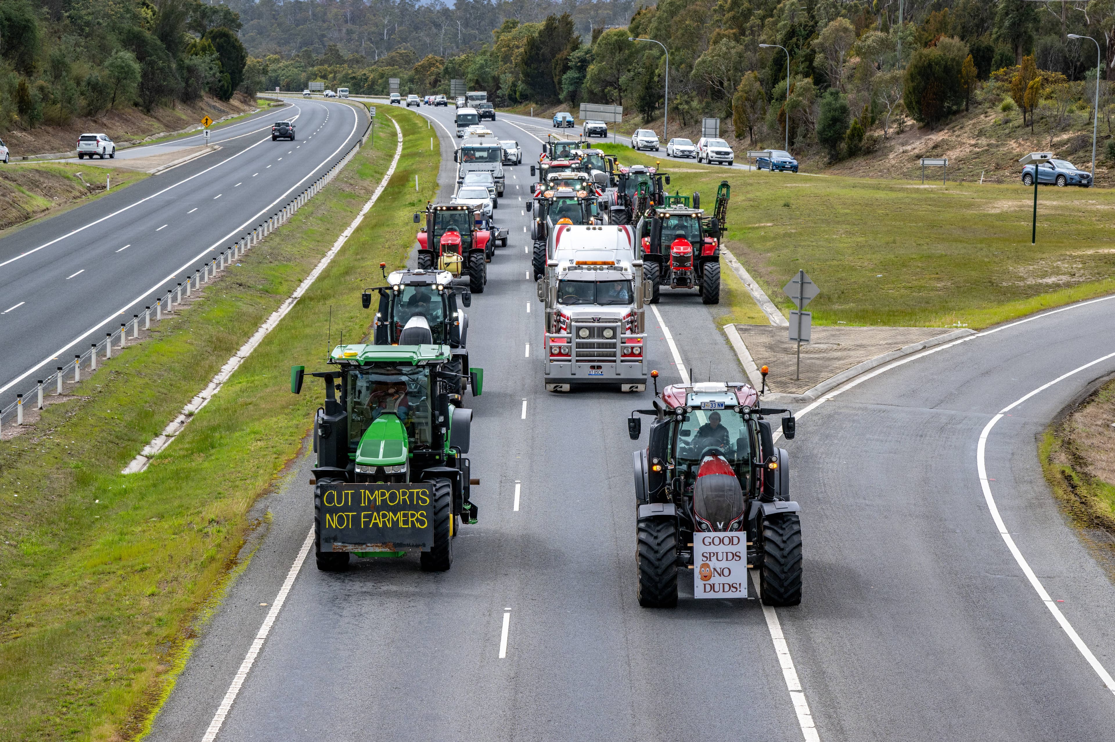 Protesting farmers drive their tractors out of Launceston, along the Bass Highway, on October 2.