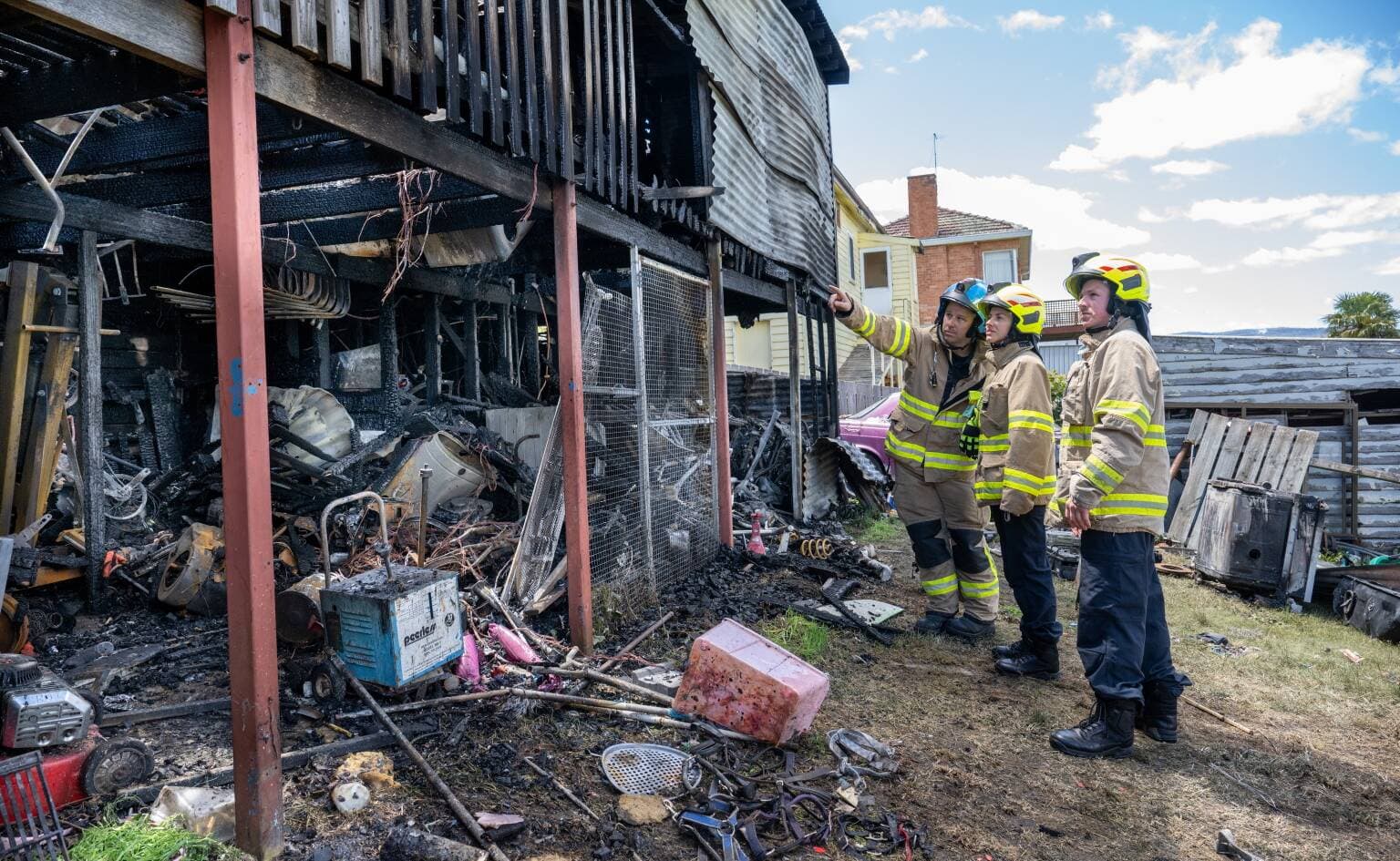 Station Officer Roger Brown with Fire Fighters Abbey Colson and Kris Evans at the rear of a house fire in Mowbray.