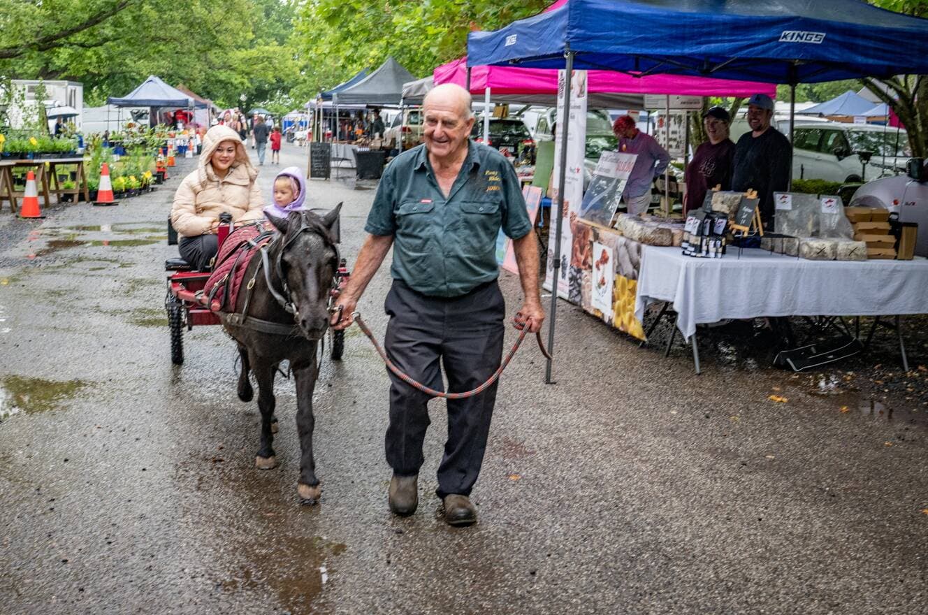 John Mills celebrates his 80th birthday at Evandale market on January 12 with Lucky and passengers Georgene McCarthy and Willow McIntosh of Launceston.