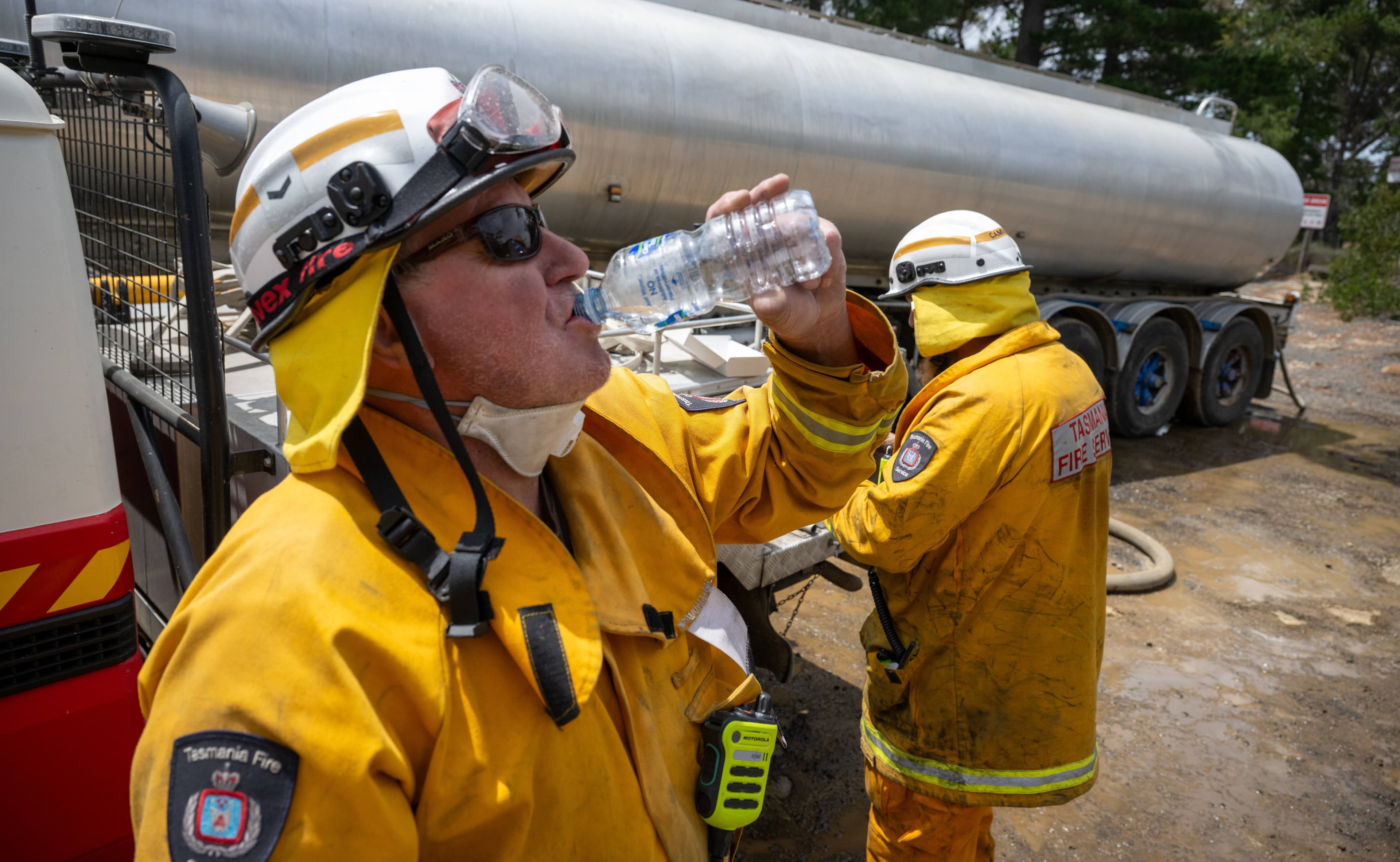 TFS volunteers Chris Hall and Hugh Cameron of Mayfield fire crew (Swansea) grab drinks and food while their tanker fills at Dolphin Sands.