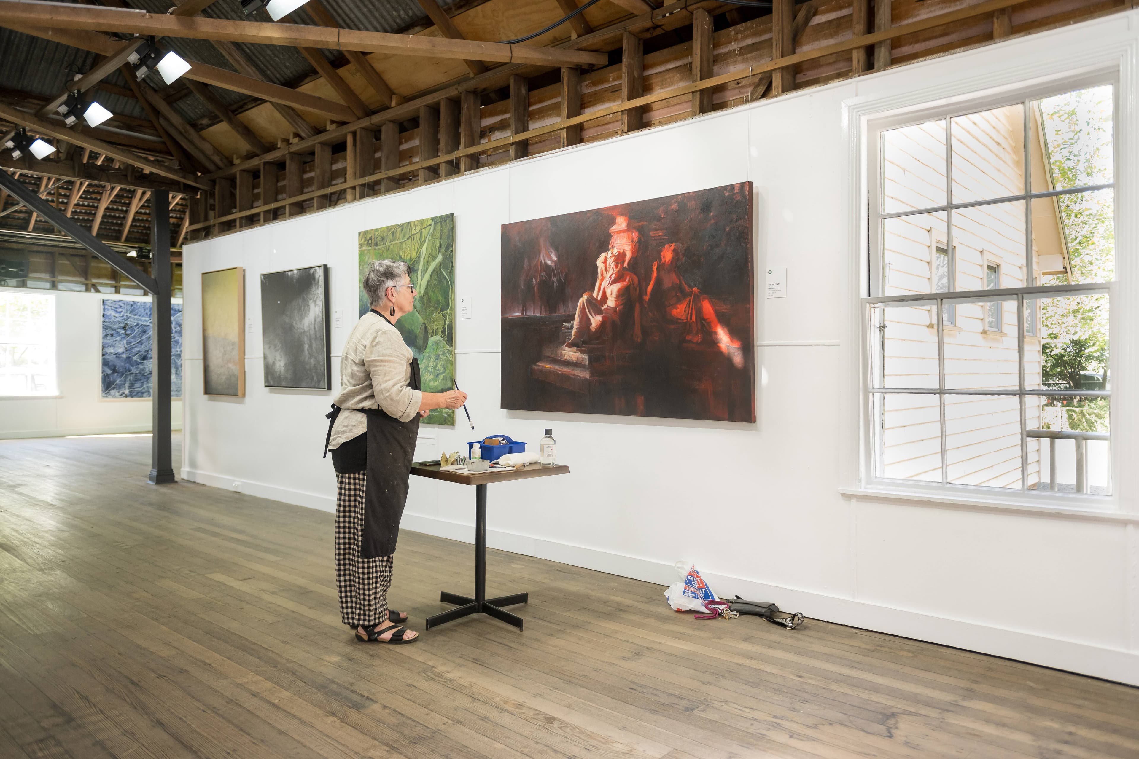 Leoni Duff attends to a touch up on at the Glover Art Prize at Falls Pavillion, Evandale.