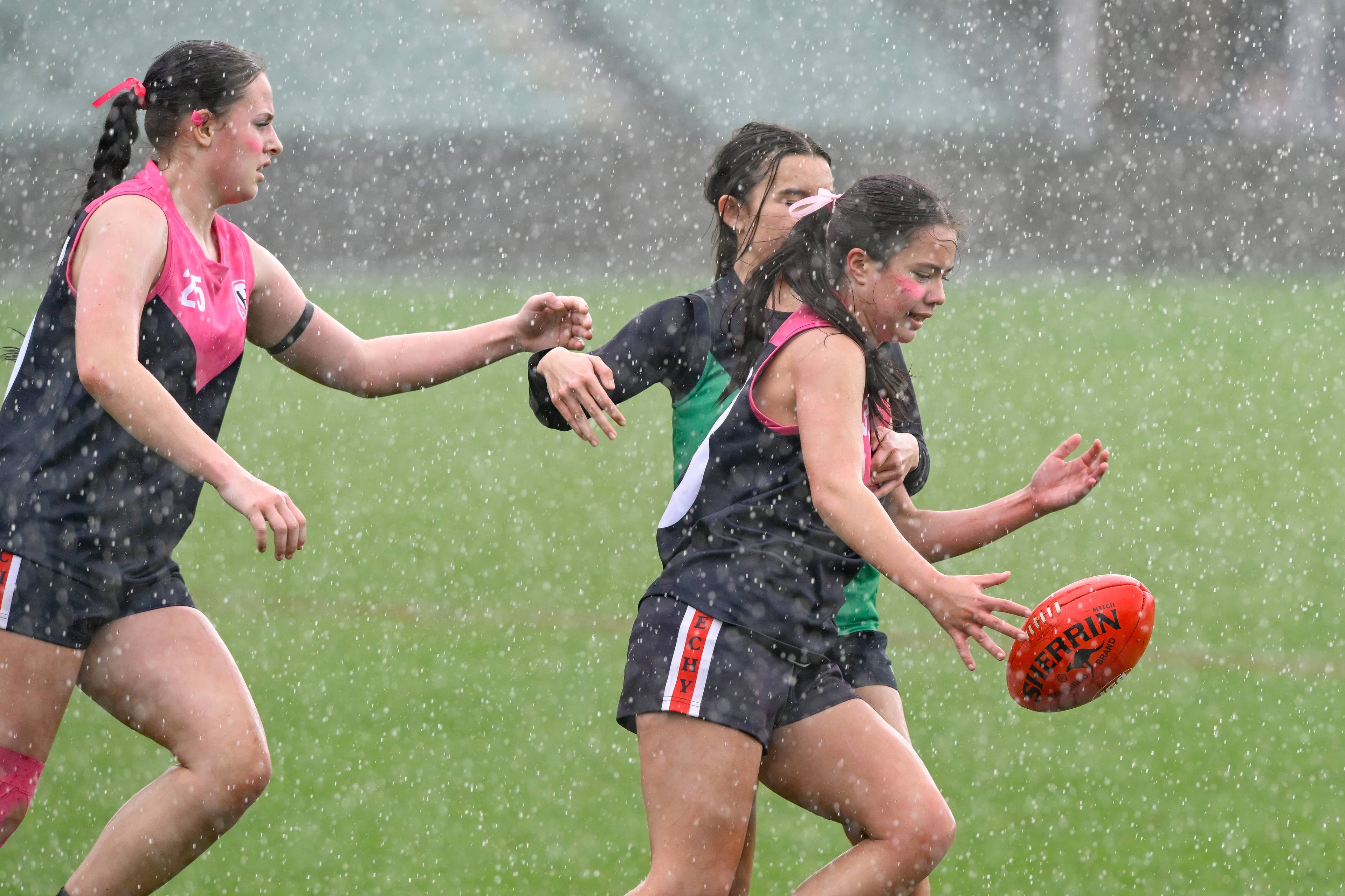 Queechy High School's Crystal Jay Burns plays during a torrential rain shower during the Girls Tassie Hawks Cup High School Football state championships at UTAS Stadium on Tuesday, September 16.