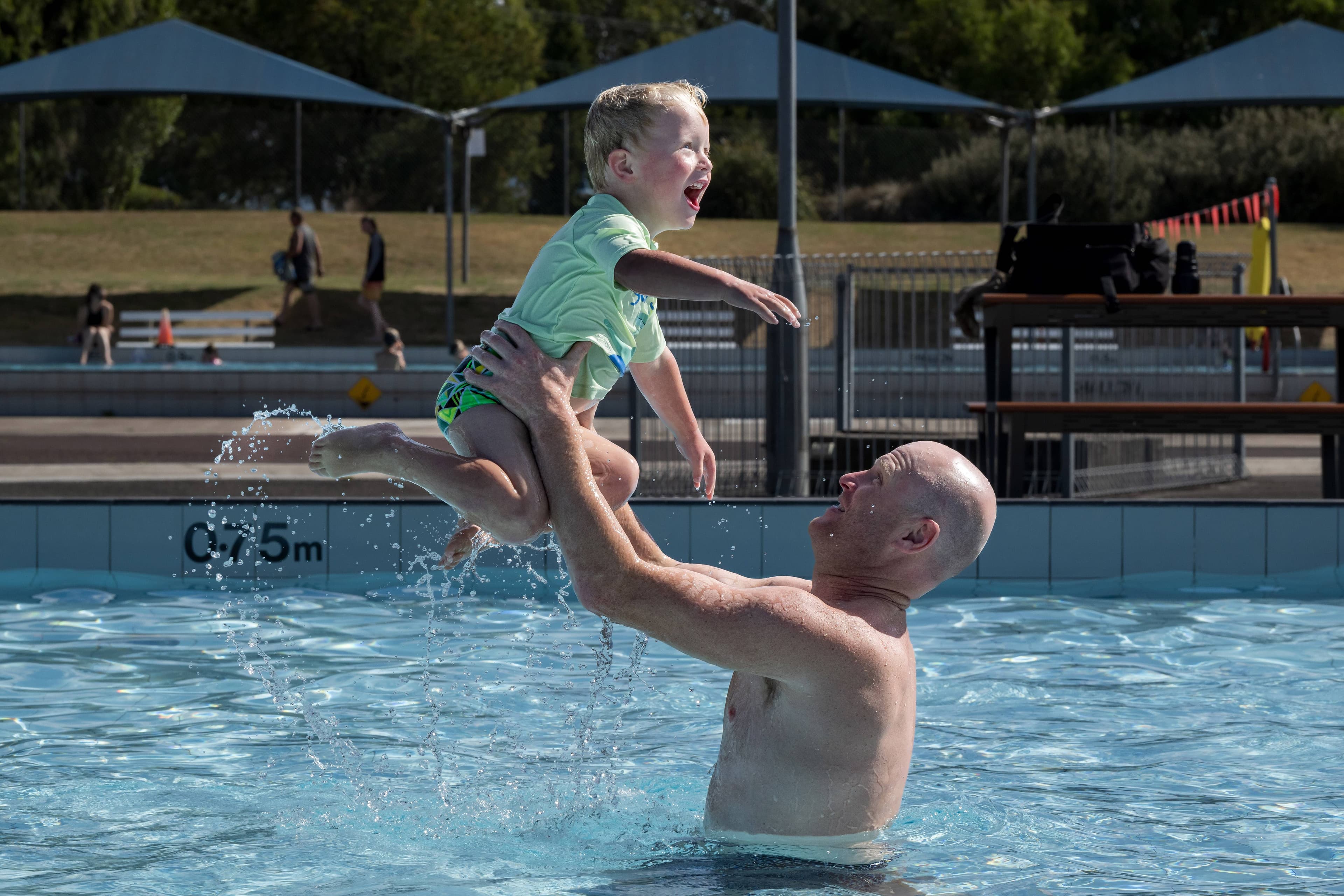 Mark Jones and two year old son Louis play at the George Town Pool in March.